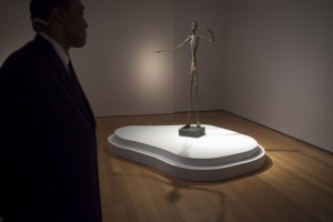 A guard stands watch over Alberto Giacometti's "L'homme Au Doigt" (Pointing man) sculpture at Christie's Auction House in the Manhattan borough of New York
