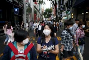 Chinese tourist wearing masks to prevent contracting Middle East Respiratory Syndrome (MERS) walk at Myeongdong shopping district in central Seoul