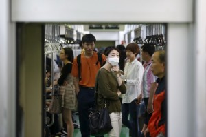 A passenger wearing a mask to prevent contracting Middle East Respiratory Syndrome (MERS) stands inside a train in Seoul