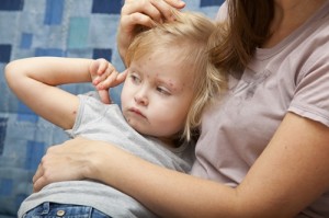 Sick girl in the arms of her mother