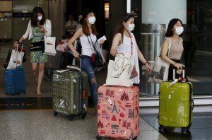 South Korean visitors arriving from Seoul are seen wearing masks at Hong Kong Airport in Hong Kong